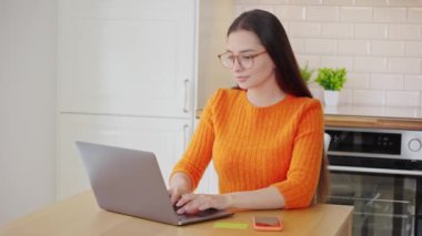Genç, çekici bir kadın, kredi kartıyla dizüstü bilgisayarla online alışveriş yapıyor. E-ticaret, iş konsepti. Serbest, uzak çalışma