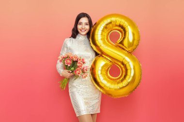 Güzel genç bir kadın elinde bir buket lale çiçeği ve 8 numaralı balon ile bahar tatilini kutluyor. 8 Mart Kadınlar Günü