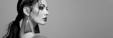 Mükemmel makyajlı esmer kız. Kıvırcık saçlı güzel bir model kadın. Bakım ve güzellik ürünleri. Saçları örgülü bir kadın. Mücevherleri olan bir model. Siyah beyaz fotoğraf
