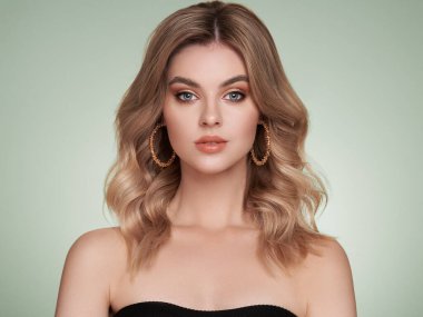 Parlak dalgalı sarı saçlı güzel bir genç kadın. Sağlıklı ciltli bir model, yakın portre. Kozmetik, güzellik ve kaplıca