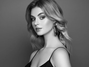 Parlak dalgalı sarı saçlı güzel bir genç kadın. Sağlıklı ciltli bir model, yakın portre. Kozmetik, güzellik ve kaplıca