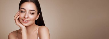 Temiz tenli güzel bir genç kadın portresi. Sağlıklı ciltli bir model, yakın portre. Kozmetik, güzellik ve kaplıca