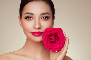 Parlak dalgalı sarı saçlı güzel bir genç kadın. Gül çiçekli kız. Sağlıklı ciltli bir model. Kozmetik, güzellik ve kaplıca