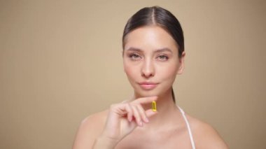 Vitaminler. Morina yağlı Omega-3 haplı mutlu güzel kıza yakın çekim. Beslenmek. D vitamini, E vitamini, balık yağı kapsülleri. Sağlıklı yaşam tarzı. Spor, Diyet Konsepti