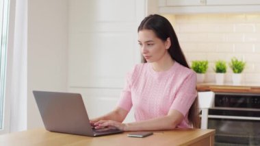 Genç, çekici bir kadın, kredi kartıyla dizüstü bilgisayarla online alışveriş yapıyor. E-ticaret, iş konsepti. Serbest, uzak çalışma