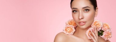 Temiz tenli güzel bir genç kadın portresi. Sağlıklı ciltli bir model, yakın portre. Kozmetik, güzellik ve kaplıca. Gül çiçekli kız.