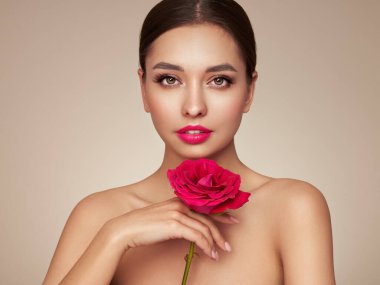 Parlak esmer saçlı güzel bir genç kadın. Gül çiçekli kız. Sağlıklı ciltli bir model. Kozmetik, güzellik ve kaplıca