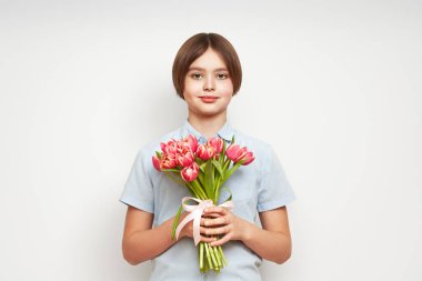 Lale buketli neşeli mutlu çocuk. Beyaz arka planda gülümseyen çocuk. Anneler Günü. Aşk ve romantik konsept