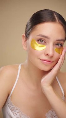 Yüz, göz bandı ve bej bir arka planda izole edilmiş cilt bakımı, güzellik ve tedaviye sahip bir kadın. Portre, insan ya da model kozmetik pedleri, sağlıklı cilt ve bakım rutiniyle cilt bakımı