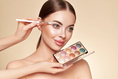 Makyaj sanatçısı Göz Gölgesi 'ni uyguluyor. Güzel Kadın Suratı. Mükemmel makyaj. Makyaj ekibi. Kusursuz Derili Güzellik Kızı. Çivi ve manikür. Göz Gölgesi Paleti