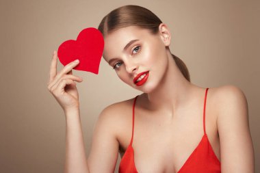 Yapay kırmızı bir kalp tutan güzel bir genç kadın. Sevgililer Günü - Bayram, Kadınlar, Sevgililer Günü, Tek Kadın, Kalp Şekli