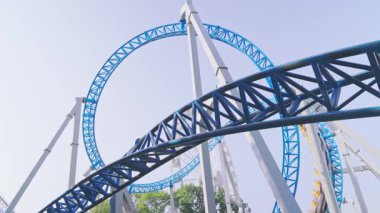 Mavi gökyüzüne karşı lunapark treni. Lunaparktaki lunaparkta hız treni. Eğlence parkında neşeli eğlenceler.