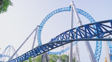 Mavi gökyüzüne karşı lunapark treni. Lunaparktaki lunaparkta hız treni. Eğlence parkında neşeli eğlenceler.