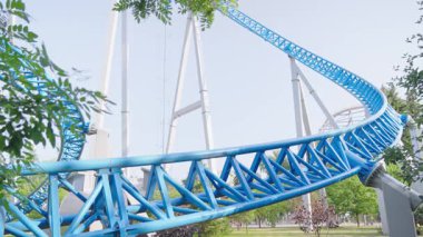 Mavi gökyüzüne karşı lunapark treni. Lunaparktaki lunaparkta hız treni. Eğlence parkında neşeli eğlenceler.