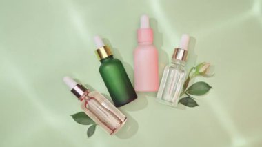 Kozmetik spa tıbbi cilt bakımı, yeşil arka planda kolajen içeren cam serum şişesi. Yaşlanma önleyici bakım, nemlendirici ve temizlik için tıbbi ürün reklamı.