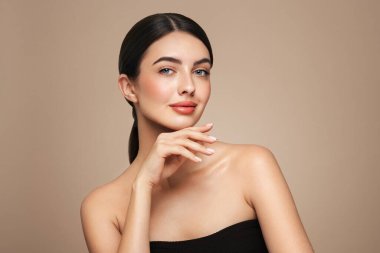 Temiz tenli güzel bir genç kadın portresi. Sağlıklı cildi olan bir model boş bir yere bakar, portreyi kapatır. Kozmetik, güzellik ve kaplıca
