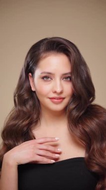 Güzel model kadınların dalgaları ve parlak saçları vardır. Kıvırcık saçlı, küpeli ve mücevherli esmer kız. Yavaş çekim videosu