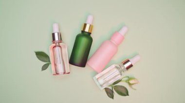 Kozmetik spa tıbbi cilt bakımı, yeşil arka planda kolajen içeren cam serum şişesi. Yaşlanma önleyici bakım, nemlendirici ve temizlik için tıbbi ürün reklamı.