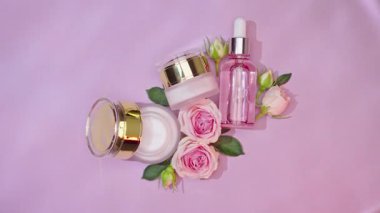 Pembe arka planda kolajen ve yaşlanma önleyici krem içeren cam serum şişesi. Yaşlanma önleyici bakım, nemlendirici ve temizlik için tıbbi ürün reklamı.