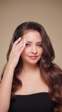 Güzel model kadınların dalgaları ve parlak saçları vardır. Kıvırcık saçlı, küpeli ve mücevherli esmer kız. Yavaş çekim videosu