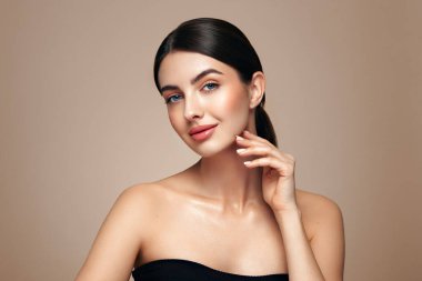 Temiz tenli güzel bir genç kadın portresi. Sağlıklı cildi olan bir model boş bir yere bakar, portreyi kapatır. Kozmetik, güzellik ve kaplıca