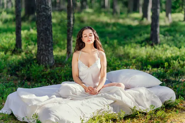 Yaz ormanında bir kadın yatakta uyur. Kız yaz ormanında uyanıyor. Eko-konfor ve rahatlama