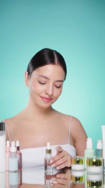 Doğal malzemelere dayalı kozmetik ürünler, fırça, tonik, vücut bakımı. Doğal kozmetik ürünleri. Açık mavi arka planda, kozmetik işlemleri için kavanozlar, şişeler ve tüplerin arasında genç bir kadın.