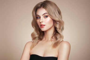 Parlak dalgalı sarı saçlı güzel bir genç kadın. Sağlıklı ciltli bir model, yakın portre. Kozmetik, güzellik ve kaplıca