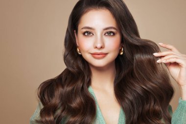Mükemmel makyajlı esmer kız. Uzun kıvırcık saçlı, gülümseyen güzel model kadın. Bakım ve güzellik saç ürünleri
