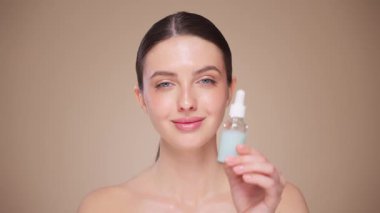 Güzel Genç Kadın Kusursuz Yüzüne Dokunuyor. Doğal Kozmetik Teni Ürünleri. Kadın nemlendirici yüz bakımı gösteriyor. İzole edilmiş arkaplanı olan yakın plan portresi yükseliyor. Yavaş çekim
