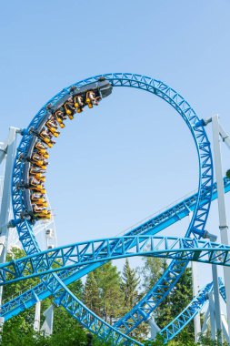Mavi gökyüzüne karşı lunapark treni. Lunaparktaki lunaparkta hız treni. Eğlence parkında neşeli eğlenceler.