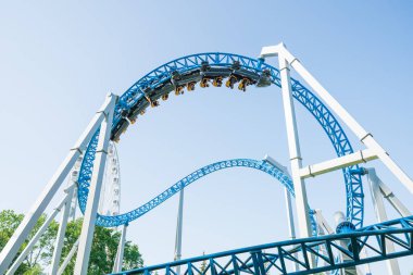 Mavi gökyüzüne karşı lunapark treni. Lunaparktaki lunaparkta hız treni. Eğlence parkında neşeli eğlenceler.