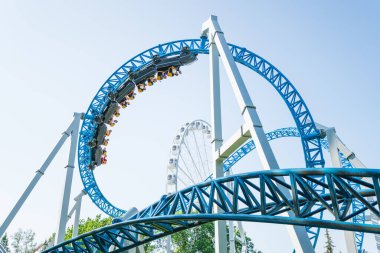 Mavi gökyüzüne karşı lunapark treni. Lunaparktaki lunaparkta hız treni. Eğlence parkında neşeli eğlenceler.