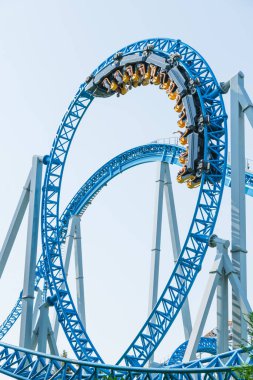 Mavi gökyüzüne karşı lunapark treni. Lunaparktaki lunaparkta hız treni. Eğlence parkında neşeli eğlenceler.