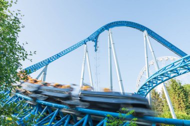 Mavi gökyüzüne karşı lunapark treni. Lunaparktaki lunaparkta hız treni. Eğlence parkında neşeli eğlenceler.