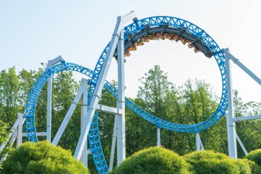 Mavi gökyüzüne karşı lunapark treni. Lunaparktaki lunaparkta hız treni. Eğlence parkında neşeli eğlenceler.