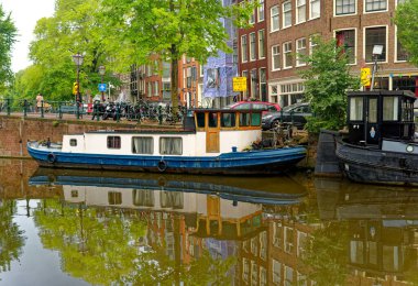 AMSTERDAM, NETHERLANDS - 24 Ağustos 2023: Amsterdam, sanatsal mirası, ayrıntılı kanal sistemi ve dar cepheli evleri ile bilinen Hollanda başkentidir..