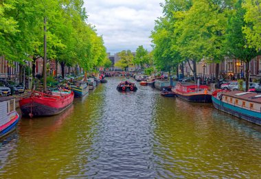 AMSTERDAM, NETHERLANDS - 9 Eylül 2023: Amsterdam, sanatsal mirası, ayrıntılı kanal sistemi ve dar cepheli evleri ile bilinen Hollanda başkentidir..