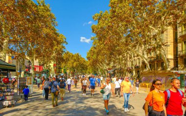 BARCELONA, SPAIN - 3 Ekim 2024: La Rambla, Barselona 'nın ikonik bulvarı, turist ve yerlilerle dolup taşan, kafeler, dükkanlar ve canlı sokak sanatçılarıyla dolu manzaralı yürüyüş alanlarının keyfini çıkaran,.