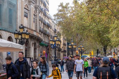 BARCELONA, SPAIN - 3 Ekim 2024: La Rambla, Barselona 'nın ikonik bulvarı, turist ve yerlilerle dolup taşan, kafeler, dükkanlar ve canlı sokak sanatçılarıyla dolu manzaralı yürüyüş alanlarının keyfini çıkaran,.