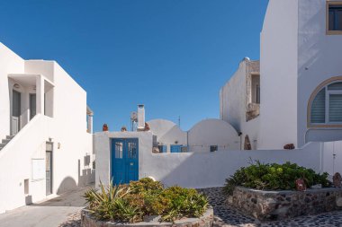 SANTORINI, GREECE - 23 Ekim 2024: Santorini beyazlatılmış mimari ve mavi kubbeler Ege 'ye karşı her yıl milyonlarca turist çekiyor..