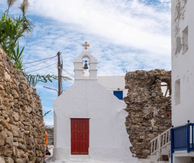 MYKONOS, GREECE - 19 Ekim 2024: Mykonos Yunanistan 'daki Beyaz Kilisenin Kırmızı Kapısı