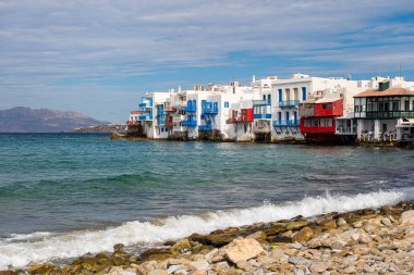 MYKONOS, GREECE - 19 Ekim 2024: Yel değirmenleri ve canlı gece hayatıyla ünlü olan Mykonos, Akdeniz cazibesi ve çarpıcı plajlar arayan turistleri çekiyor.