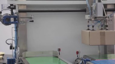 Otomatik Boşaltma Emme Kolları Taşıyıcı Kayışından Kutuları Seçiyor