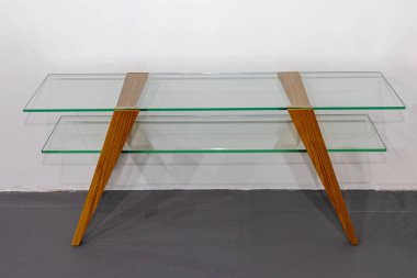 Çift camlı masa ve tahta bacaklı ofis mobilyası.