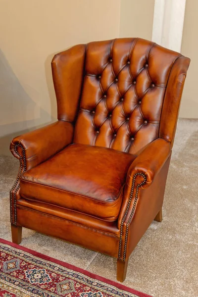 地毯地板上的全谷物豪华棕色皮革扶手椅 — 图库照片