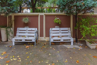 Kullanılmış kargo paletlerinden yapılmış iki beyaz bank koltuğu.