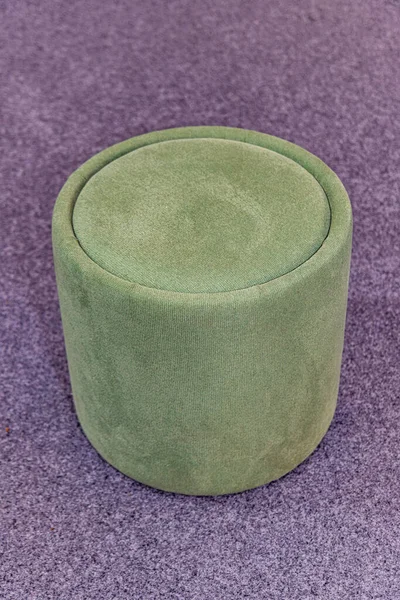 カーペットフロアの小さな丸い緑のテキスタイルフットスツール — ストック写真