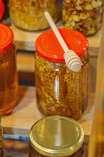 伍登蜂蜜调酒师勺子与蜂窝在罐子里 — 图库照片