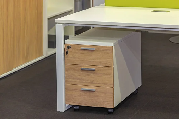 Cabinet With Three Drawers Under Work Desk in Office